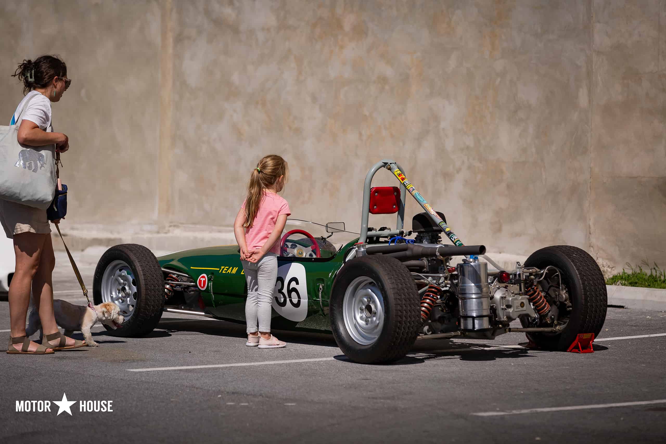 Little Girl looks at race car at the Motor House Auto & Motor Show